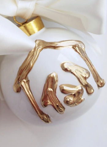Gold manger ornament on white ceramic ball