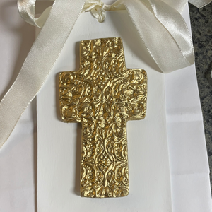 Gold embossed cross on white wood